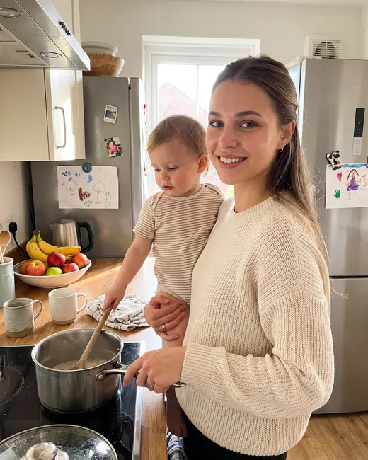 A mom creator cooking with her toddler on her hip